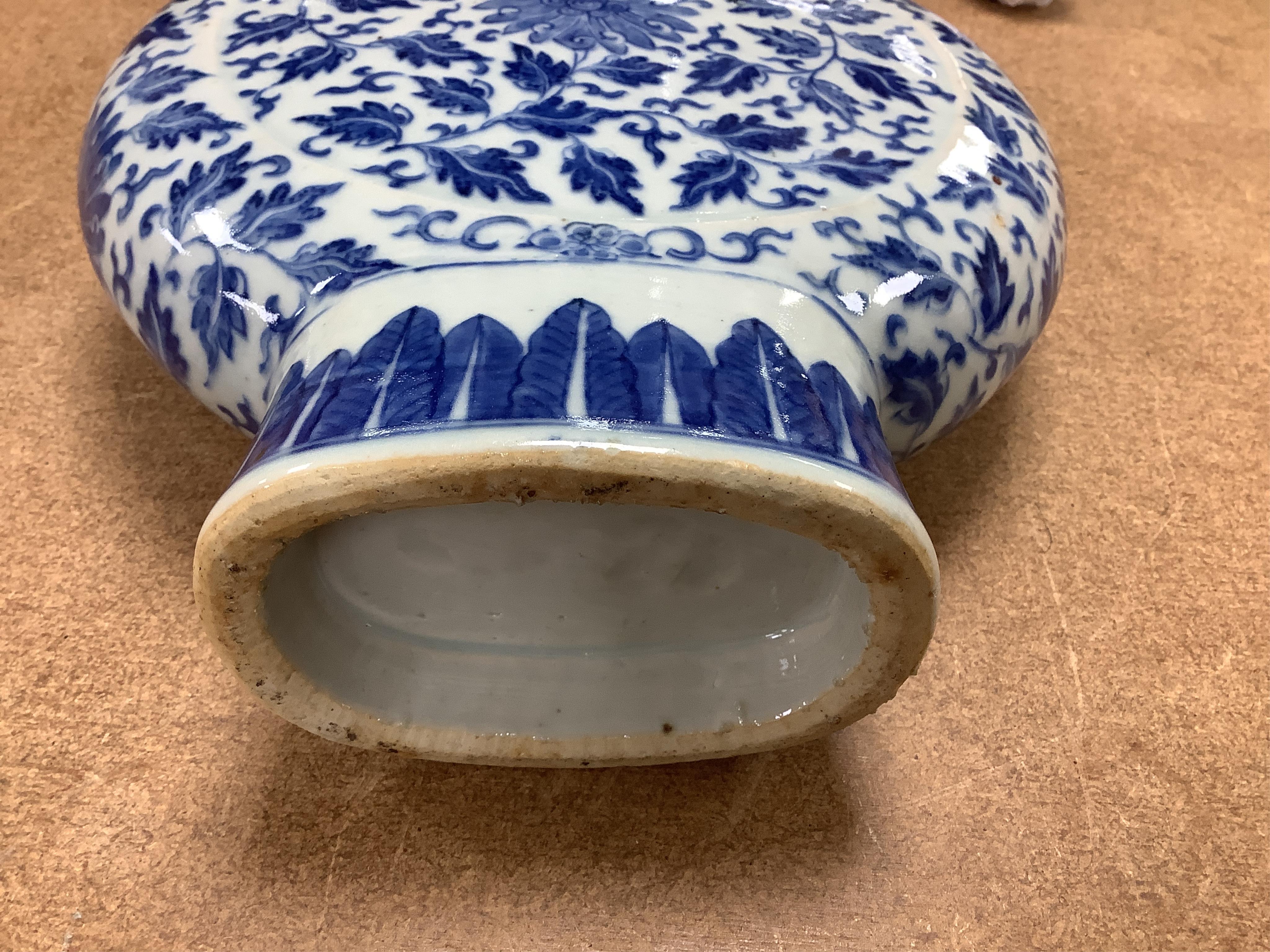 A 19th century Chinese blue and white moon flask on a hardwood stand, overall 35cm high. Condition - typical minor glaze imperfections